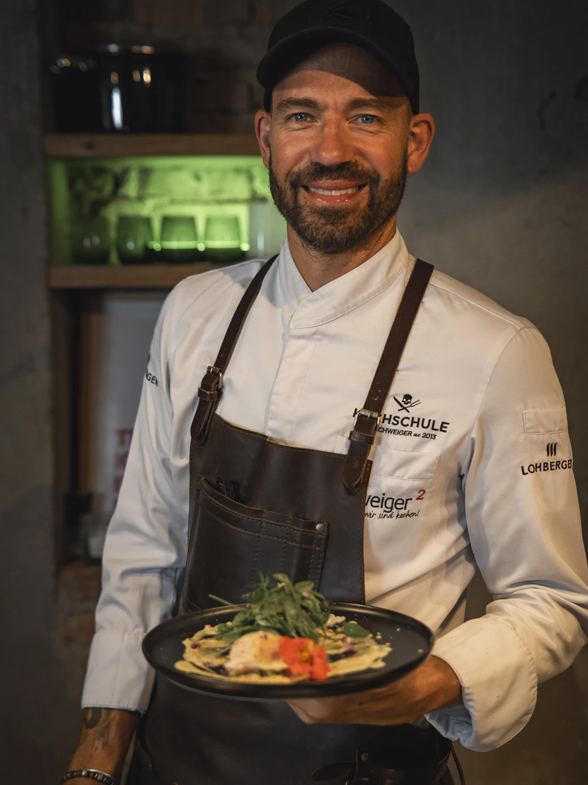 Profikoch Andi Schweiger mit einem fertigen Gericht in der Hand: Fisch Souse Vide | gebratener Blumenkohl | Curry Joghurt | Kräutersalat Profikoch Andi Schweiger mit einem fertigen Gericht in der Hand: Fisch Souse Vide | gebratener Blumenkohl | Curry Joghurt | Kräutersalat